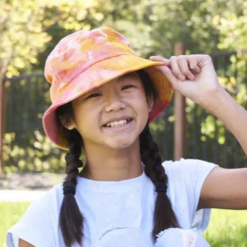 kid wearing tie-dyed hat